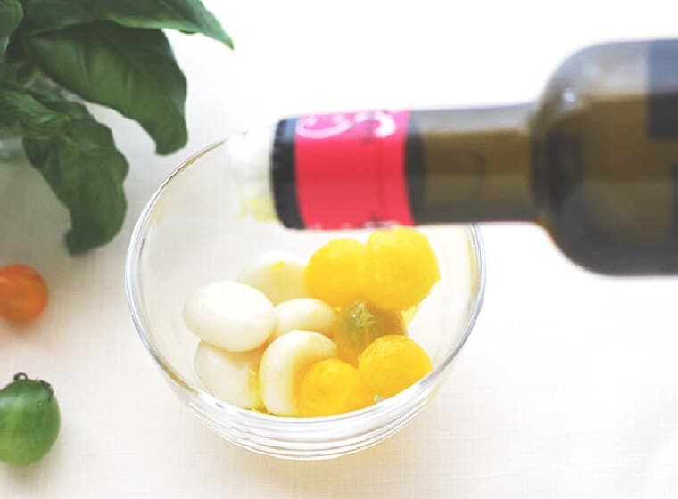 器に湯むきしたミニトマトとリコッタ白玉を盛り付け、オリーブオイル、塩をふり、バジルを飾る。