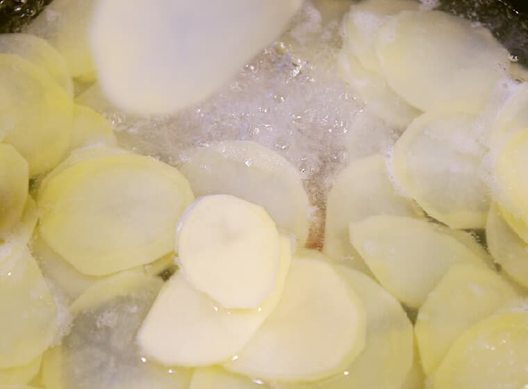 鍋に湯を沸かし、塩をひとつまみ入れる。煮立った湯にスライサーでスライスしながらメークインを入れ、1～2分茹でる。
